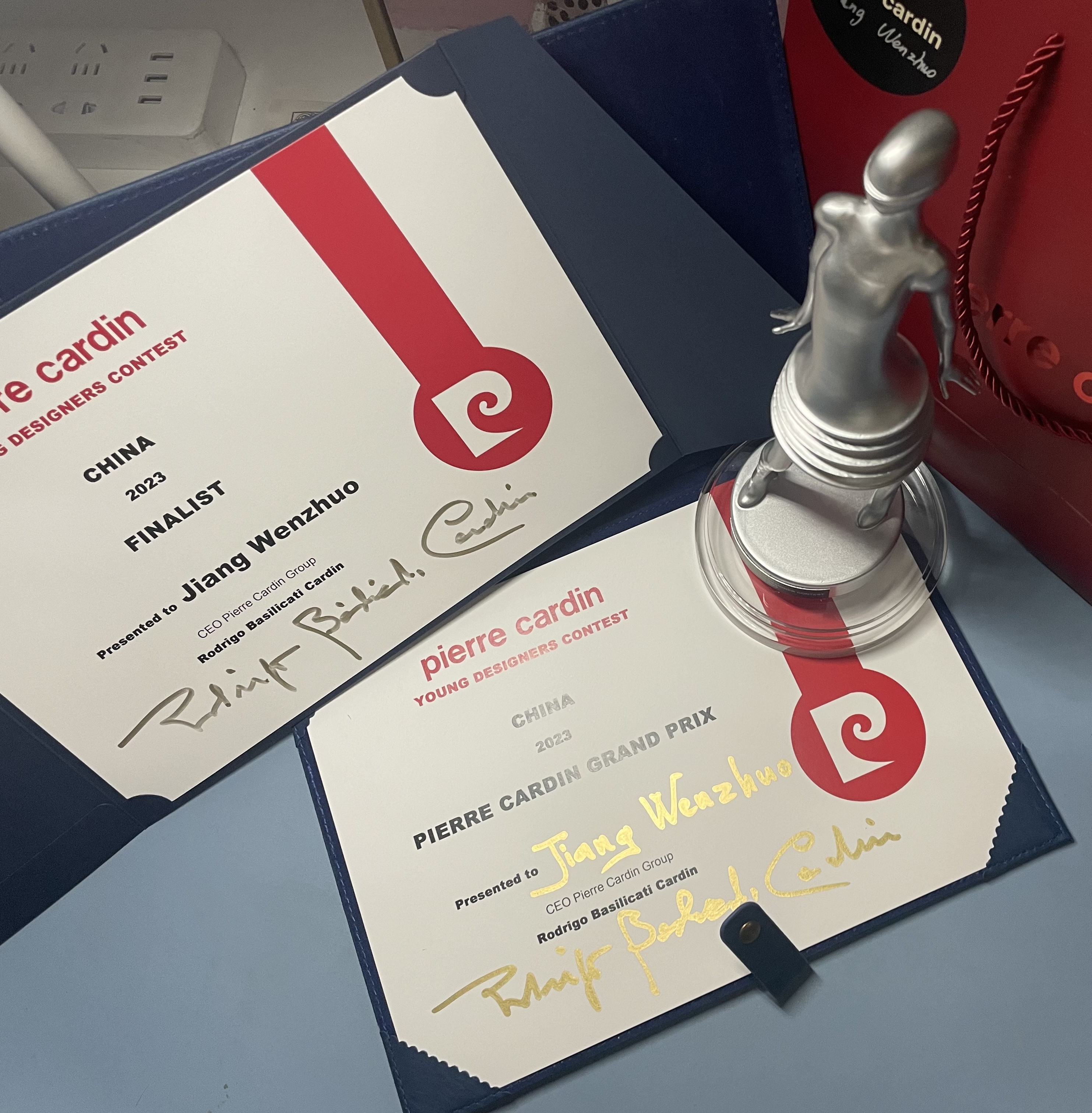 20230728-2022级研究生江文卓荣获法国皮尔卡丹青年设计师大赛总冠军奖-江文卓-获奖证书及奖杯.jpg